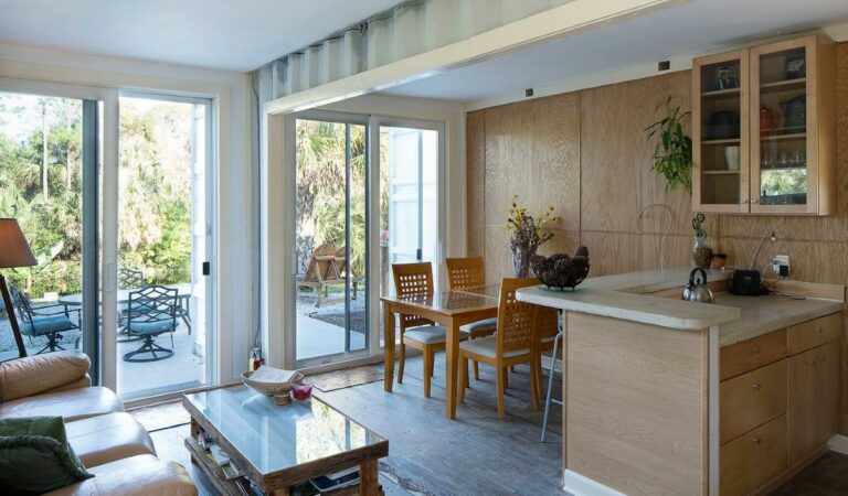 Salon d'une maison en containers avec vue sur le jardin